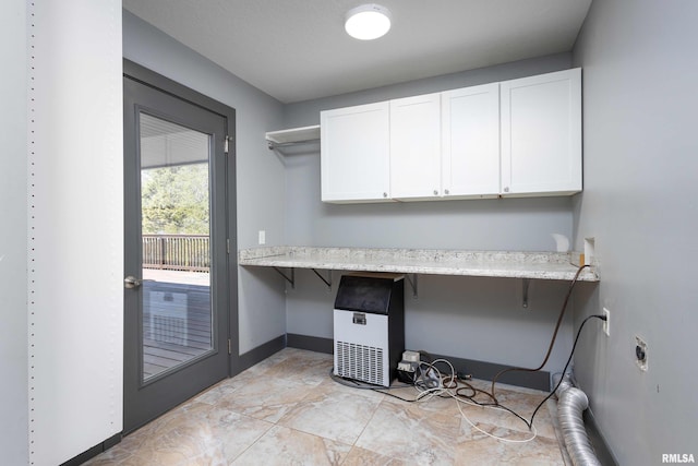 laundry room with hookup for an electric dryer, baseboards, and cabinet space