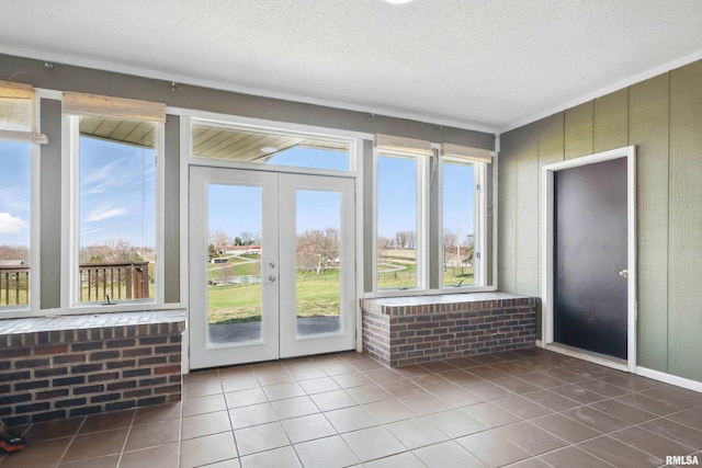 unfurnished sunroom with french doors and a healthy amount of sunlight