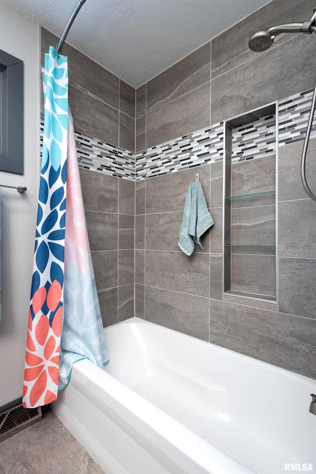 bathroom featuring shower / tub combo, visible vents, and a textured ceiling