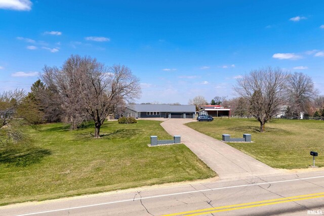 20874 270th St, Eldridge, IA 52748 - ranch-style house featuring concrete driveway, a front lawn, and a garage