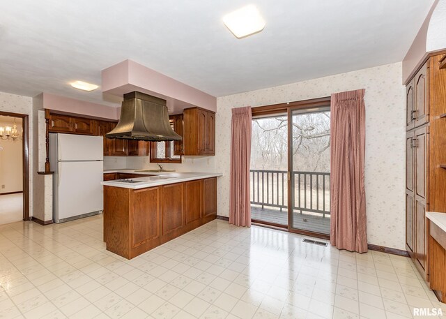 9721 234th St N, Port Byron, IL 61275 - kitchen with freestanding refrigerator, wallpapered walls, island exhaust hood, a peninsula, and light countertops