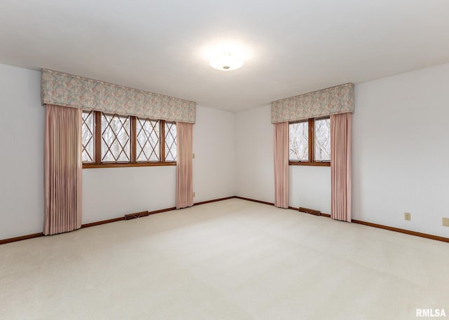 carpeted spare room featuring baseboards