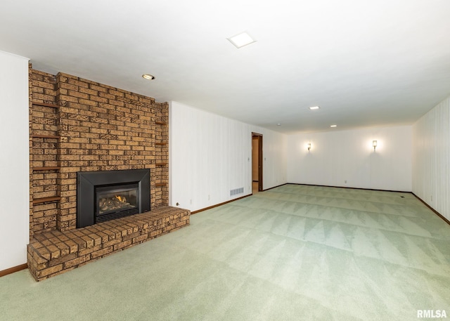 unfurnished living room with visible vents, a fireplace, baseboards, and carpet