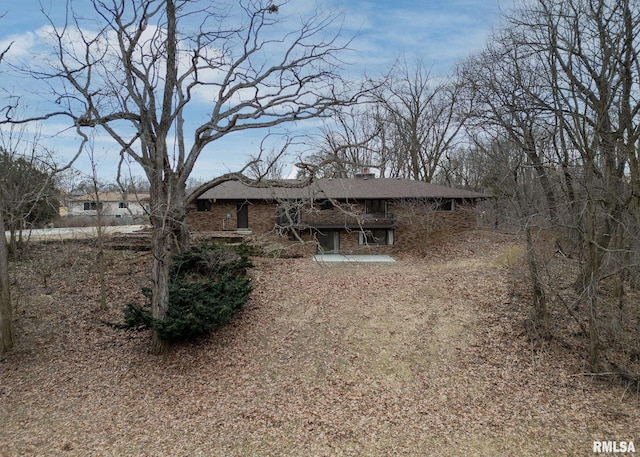 view of front of house with brick siding and a chimney