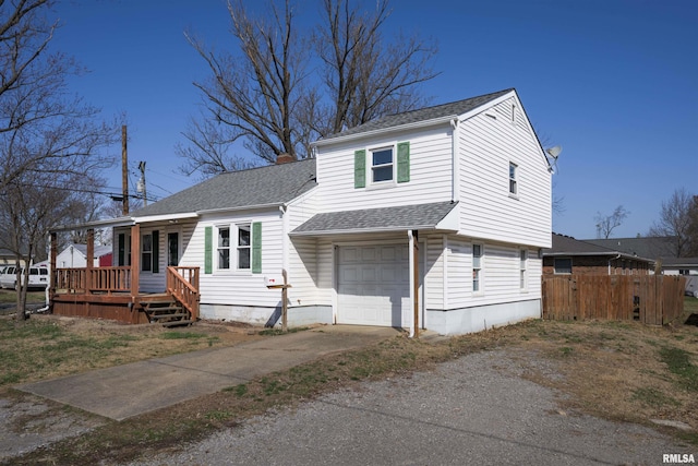 view of front facade featuring concrete driveway, an attached garage, fence, and a shingled roof