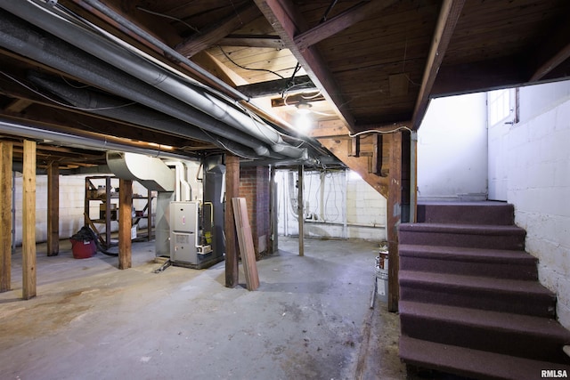 unfinished basement with stairs and heating unit