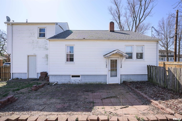 rear view of property with a patio area, a shingled roof, a chimney, and fence
