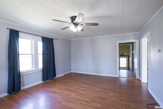 spare room with baseboards, wood finished floors, a ceiling fan, and ornamental molding
