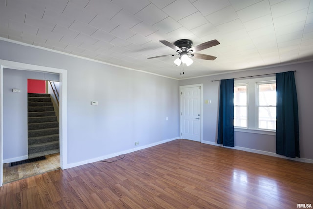 spare room with visible vents, wood finished floors, ceiling fan, and crown molding