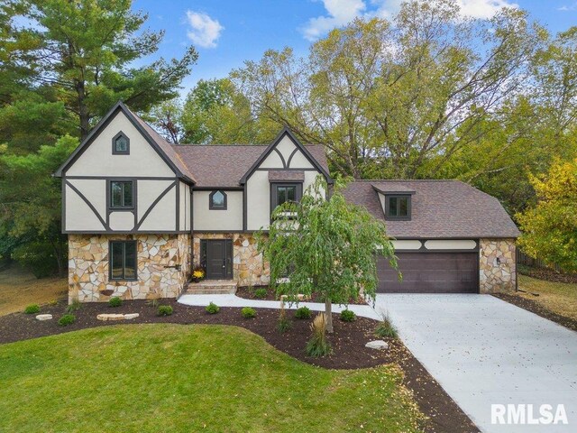 tudor home featuring stucco siding, stone siding, concrete driveway, and a shingled roof