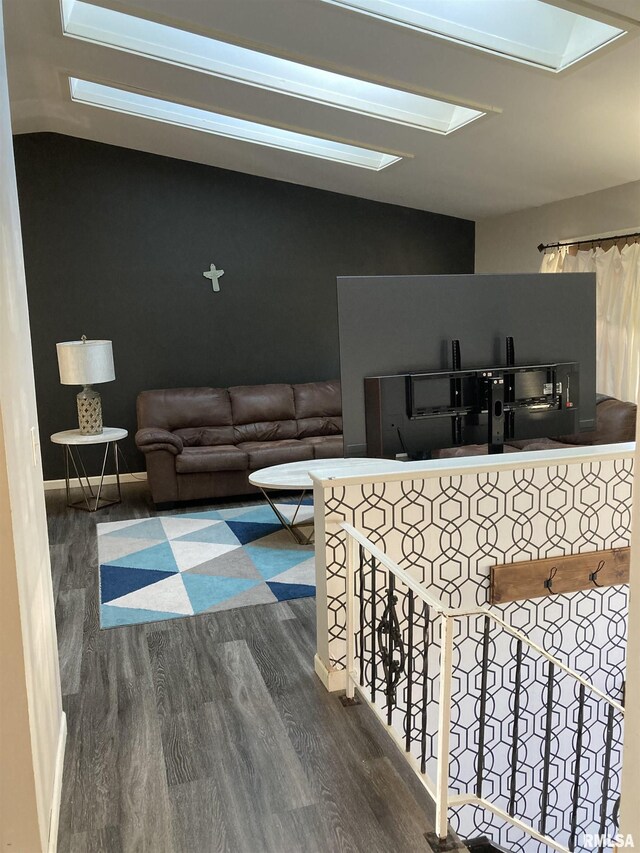 living area with vaulted ceiling and wood finished floors