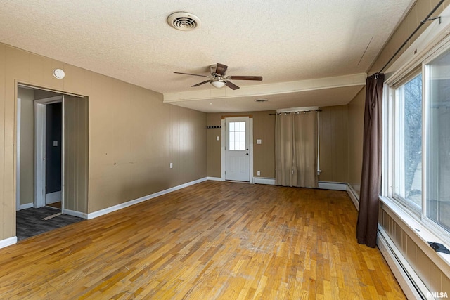 1500 W Tyler St, Herrin, IL 62948 - unfurnished room featuring visible vents, baseboard heating, ceiling fan, and light wood finished floors