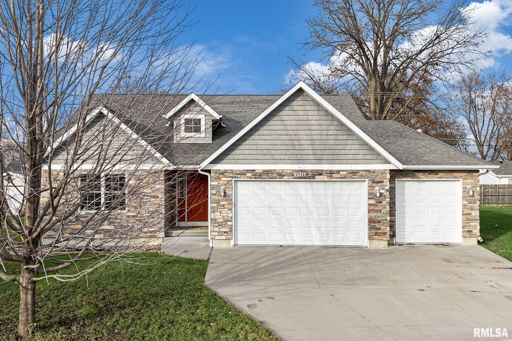 view of front facade with an attached garage, a shingled roof, stone siding, and driveway