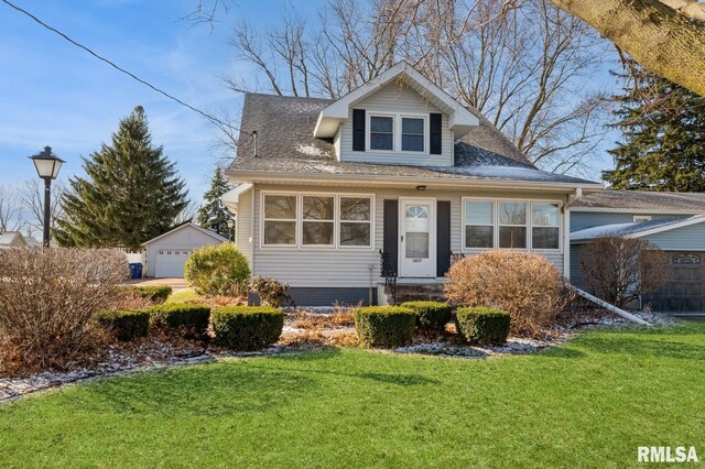 bungalow-style house featuring a garage, an outdoor structure, a front lawn, and a shingled roof