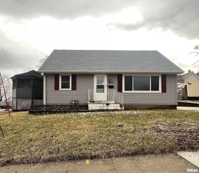 view of front of house featuring a front yard and roof with shingles