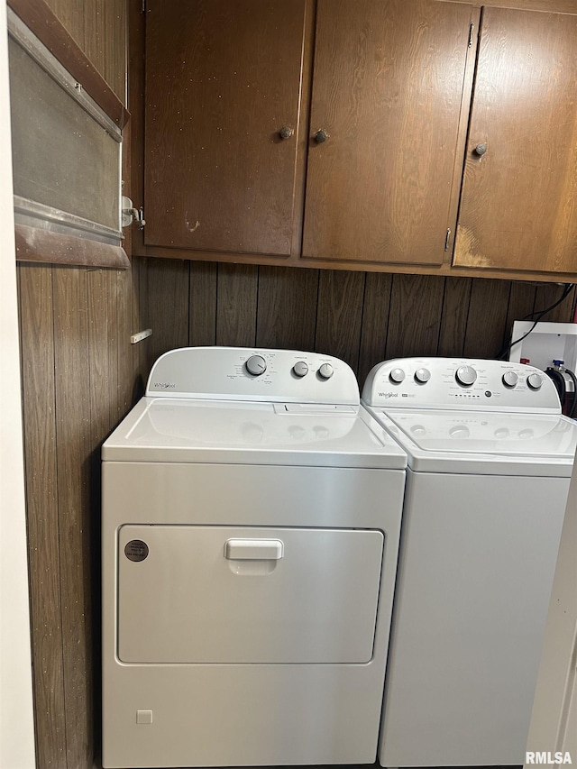 clothes washing area featuring cabinet space and independent washer and dryer