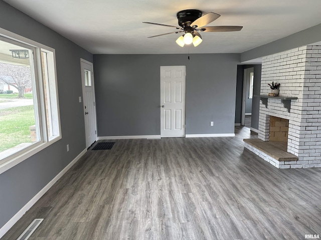 unfurnished living room featuring visible vents, baseboards, a fireplace, wood finished floors, and a ceiling fan