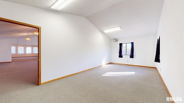 unfurnished room with a healthy amount of sunlight, carpet, and vaulted ceiling