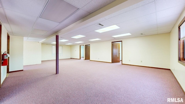 below grade area featuring visible vents, baseboards, a paneled ceiling, and carpet