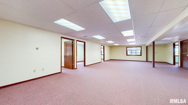 below grade area featuring a paneled ceiling, carpet, and baseboards