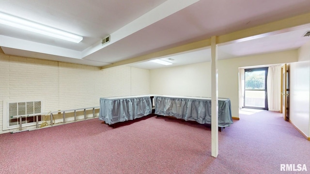 interior space with visible vents, brick wall, and carpet flooring