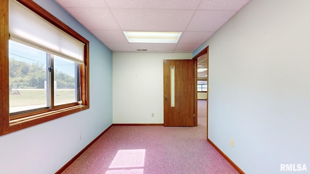 unfurnished room with a drop ceiling, carpet flooring, visible vents, and baseboards