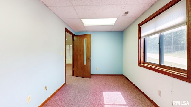 carpeted spare room featuring a drop ceiling, visible vents, and baseboards