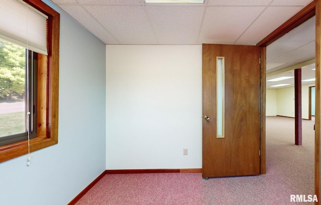 carpeted spare room with a paneled ceiling and baseboards