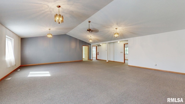 unfurnished room with carpet flooring, lofted ceiling, a notable chandelier, and a wealth of natural light