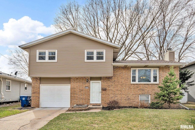 tri-level home featuring brick siding, an attached garage, a chimney, and a front lawn