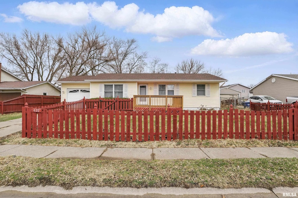 ranch-style house featuring a garage and a fenced front yard