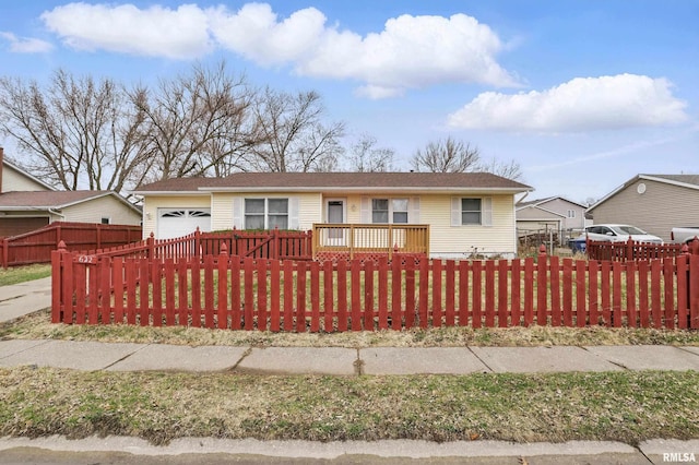 ranch-style house featuring a garage and a fenced front yard