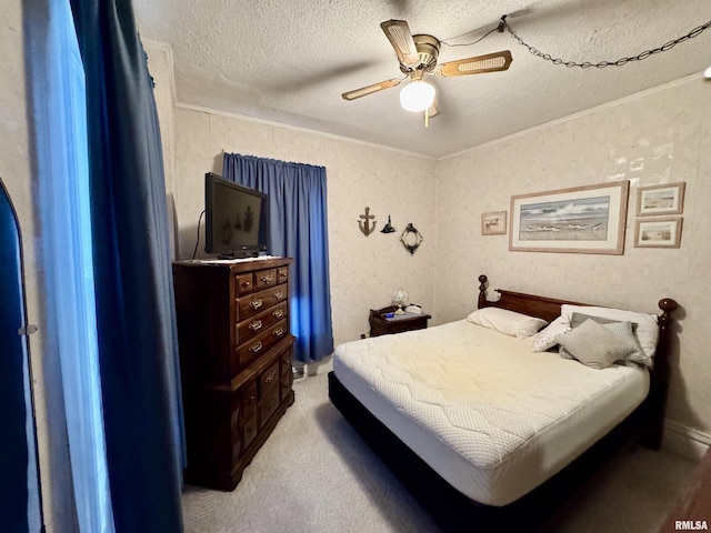 bedroom with ceiling fan, ornamental molding, light colored carpet, and a textured ceiling