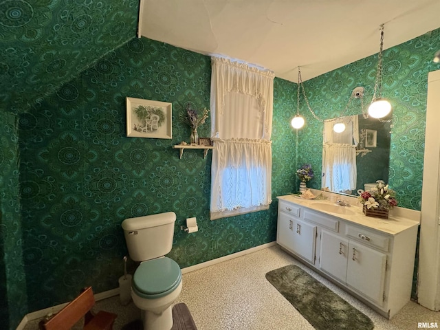 bathroom featuring wallpapered walls, vanity, toilet, and baseboards