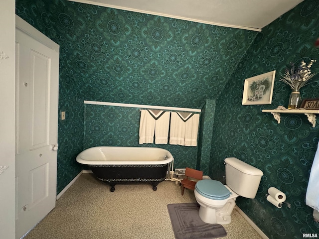 full bathroom with baseboards, toilet, a freestanding tub, and wallpapered walls
