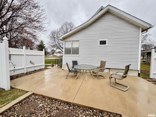 rear view of property with outdoor dining area, fence, and a patio area