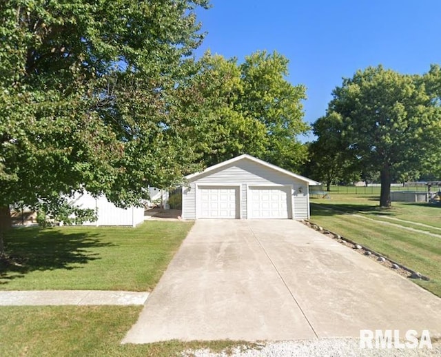 view of front of property with an outbuilding, a detached garage, and a front lawn