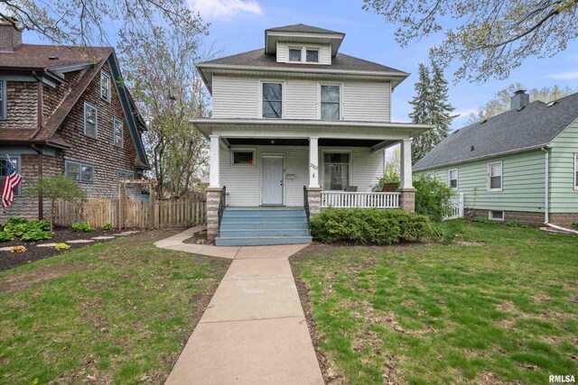 american foursquare style home with a porch and fence