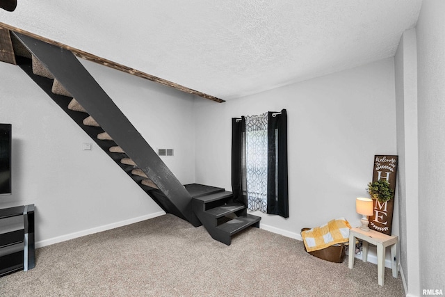 stairs with baseboards, visible vents, a textured ceiling, and carpet