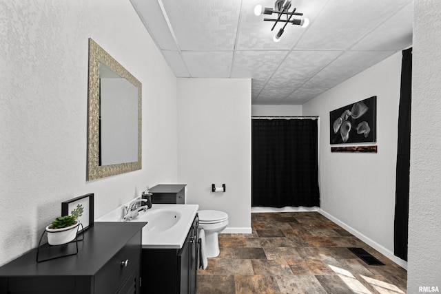full bath with visible vents, toilet, stone finish floor, a shower with shower curtain, and baseboards