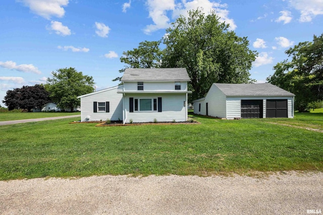 view of front of house featuring a front lawn, a detached garage, and an outdoor structure