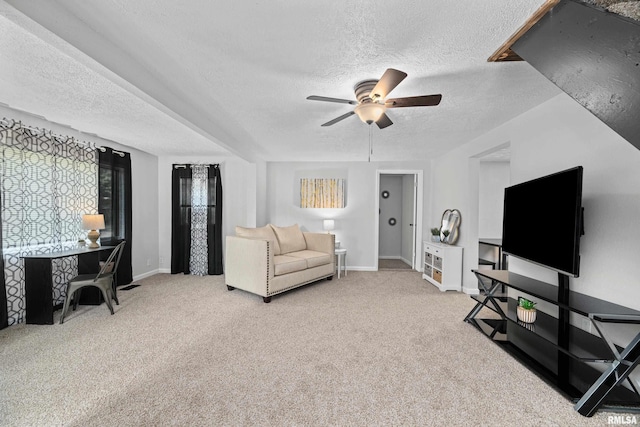 carpeted living area featuring baseboards, a textured ceiling, and ceiling fan