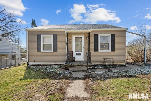 bungalow with a front yard and fence