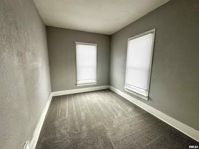carpeted spare room featuring baseboards