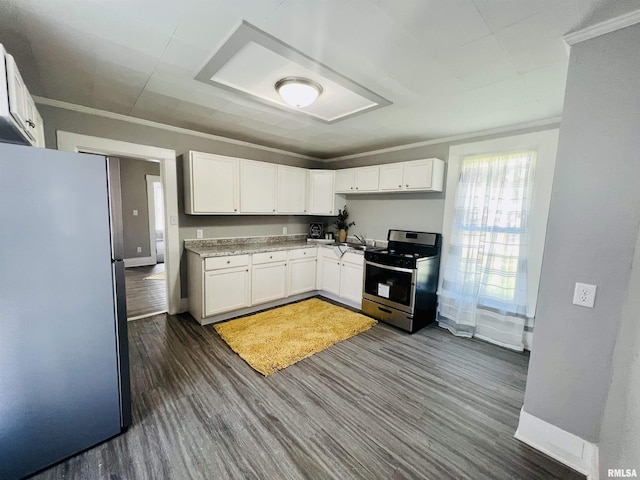 kitchen featuring baseboards, dark wood-style flooring, stainless steel appliances, white cabinets, and crown molding