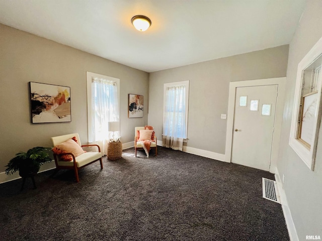 living area featuring visible vents, baseboards, and carpet floors