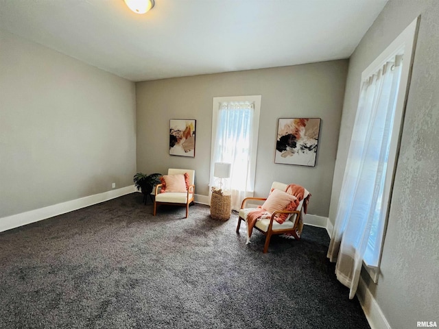 sitting room with baseboards and dark carpet