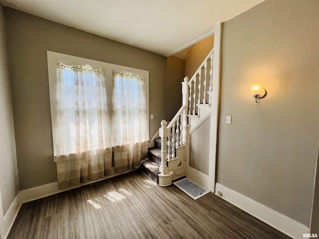 stairs with visible vents, baseboards, and wood finished floors