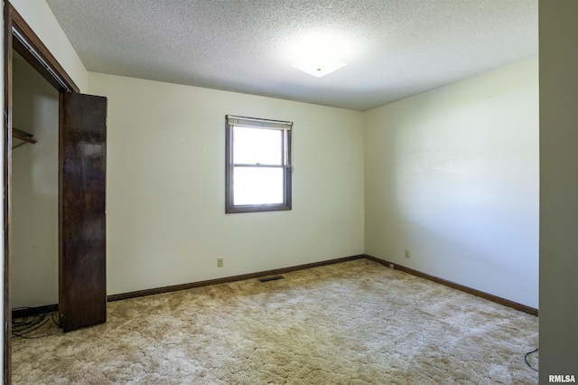 unfurnished bedroom with visible vents, baseboards, carpet, and a textured ceiling