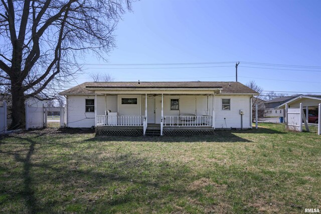 view of front of property with a porch, a front lawn, and roof with shingles